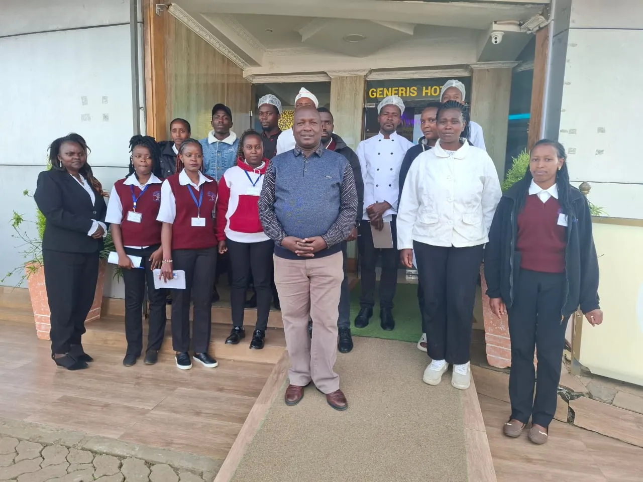 Generis Hotel staff, including kitchen and housekeeping teams, at the hotel entrance in Molo